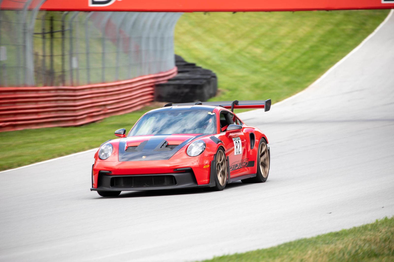 Bradshaw Autosport 992 GT3 RS #82 exiting the corner under the bridge at Mid-Ohio Sports Car Course